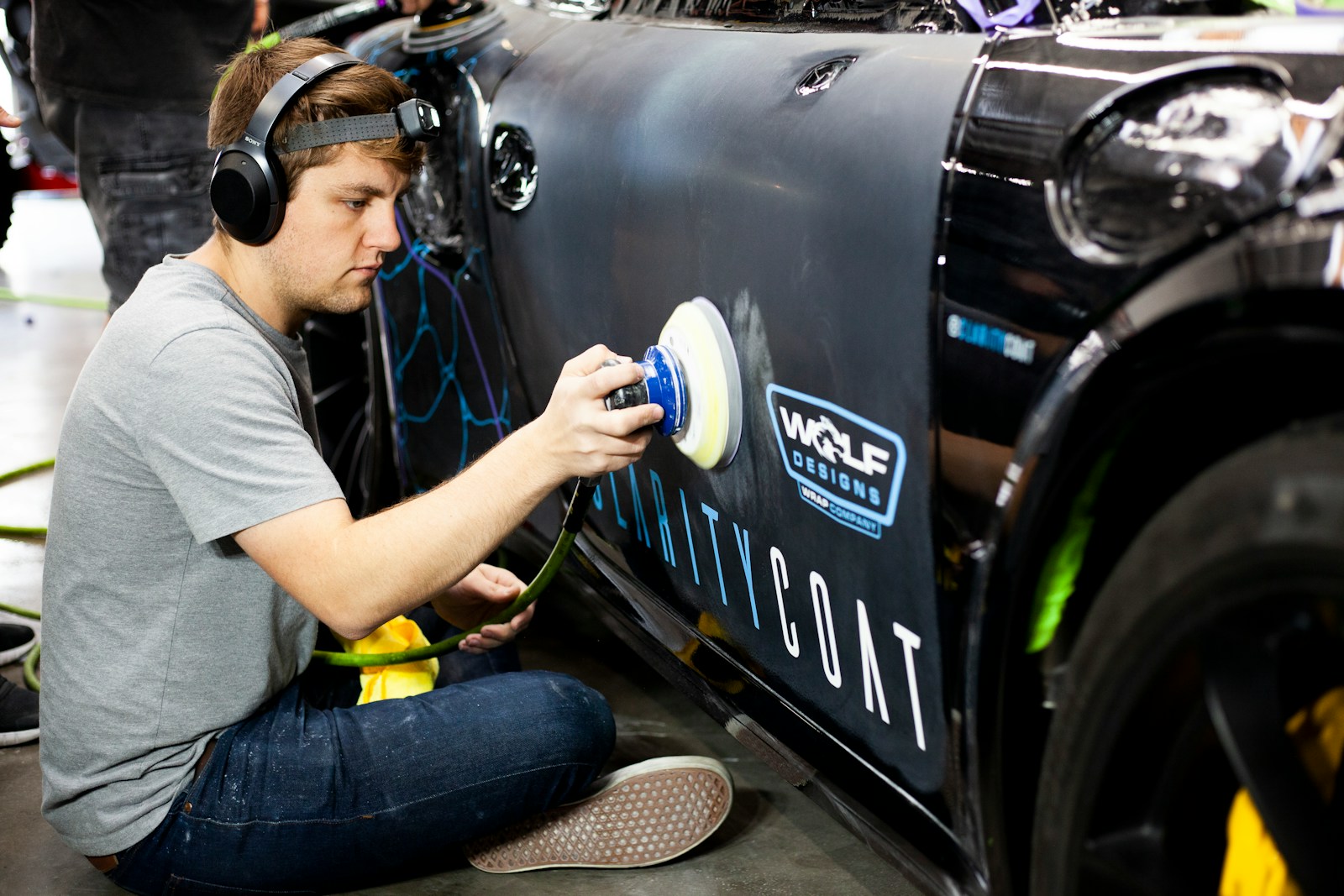 a man is painting a car with a spray gun